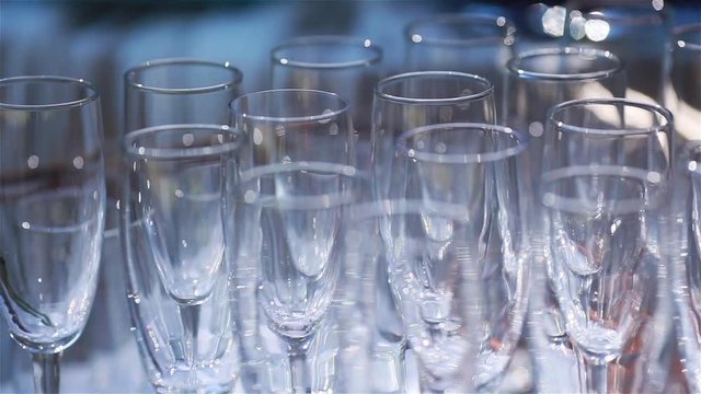 Empty glasses on table macro close up rack focus shallow dof. Many clean transparent glasses standing on cloth arranged ready for celebration - fine dining tableware glassware food and drink industry