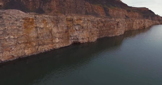Flight to drone sand quarry. The sheer side of the lake.