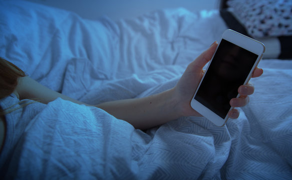 Girl In Bed Holding Smart Phone At Night Close Up, Blank Screen