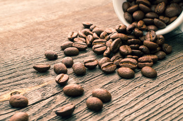 Cup full of coffee beans on the wooden table