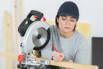 woman with circular saw in workshop