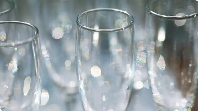 Glassware macro close up. Rims of empty glasses set for sparkling wine prepared to be poured on festive night celebration birthday anniversary or wedding - changing focus shallow depth of field