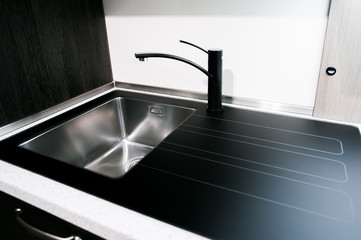 Angle view of kitchen sink with gold faucet