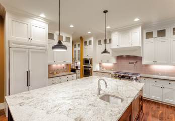 Kitchen Interior with Island, Hardwood Floors, and Pendand Lights in New Luxury Home