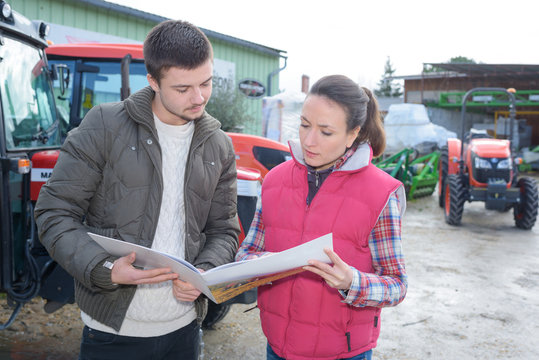 saleswoman convincing young famrer to buy new agricultural machinery