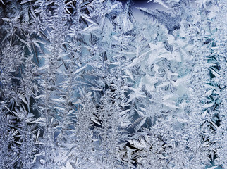 a beautiful festive pattern of transparent crystals of frost on frozen glass