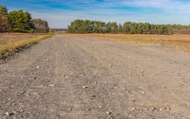 Fall landscape with country macadam road leading to remote Ukrainian village Hetmanka in Poltavsk region