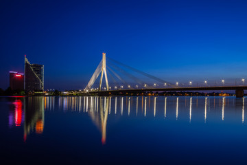 Illuminated bridge at twilight in Riga, Latvia.