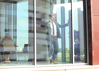 Businessman talk to cellphone and look out of window.