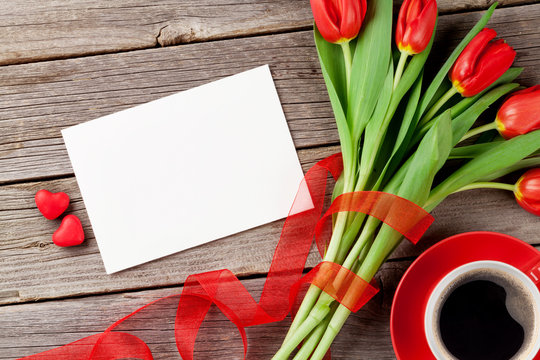 Red tulips, greeting card and candy hearts