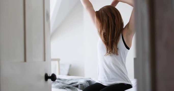 Young adult female getting up in the morning