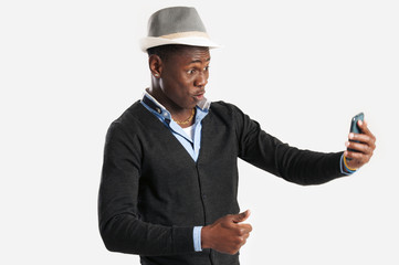 Portrait of surprised young african guy looking at cell phone