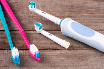 electric and manual toothbrushes on the wooden background