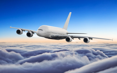 Fototapeta na wymiar Huge airplane flying above clouds in dramatic sunset