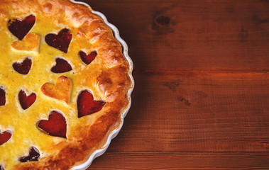 strawberry cake for Valentine's Day with hearts on a wooden background