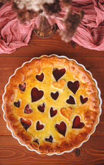 strawberry cake for Valentine's Day with hearts on a wooden background