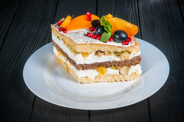 Delicious cake on a wooden black background