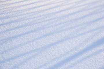 Smooth snow surface with shadow from the fence