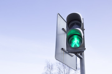 Traffic light with a burning green board on the sky