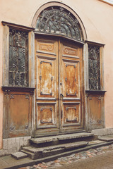Old doors and windows. Building with wrought iron ornament. Entrance to abandoned house.