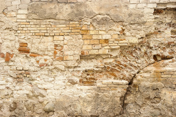 Fototapeta premium Aged wall of bricks. Old damaged cement. Castles will turn into ruins.