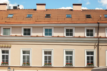 Windows of classic building. Rooftop and blue sky. Hotel in small town.