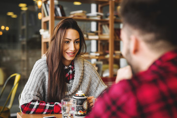 Smiling hipster couple in cafeteria.