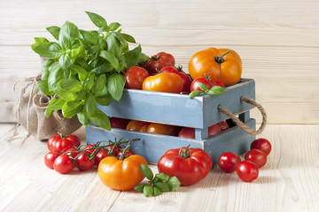 Sweet ripe tomatoes  in wooden box on wooden table