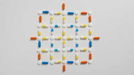 multi colored capsules forming big squat on white background