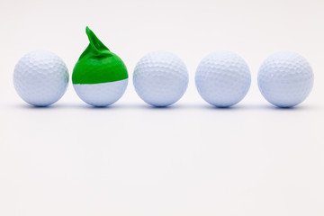 White golf balls with funny cap on the white background.