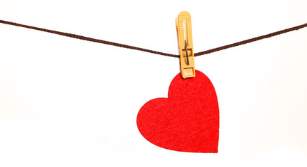 Red heart from dense fabric on a clothespeg on a rope