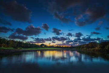 Fototapeta na wymiar Beautiful sunset over the lake near the golf course in a tropica
