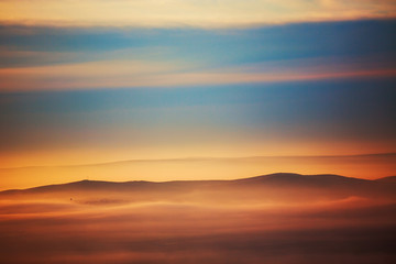 Fototapeta na wymiar Mountain layer in morning sun ray and winter fog.