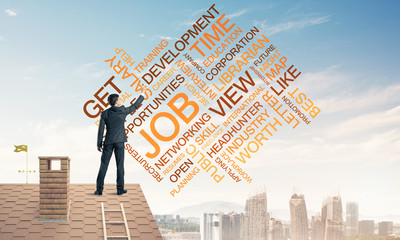 Young businessman standing on house roof and writing leadership 