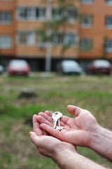 man holds keys to apartment on a background