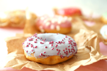 Tasty colorful donut on wooden table, close up view