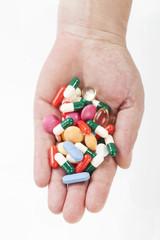 Top view of female hands holding different pills
