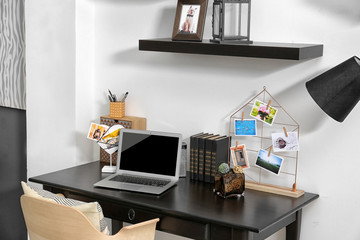 Workplace with laptop on table in modern room