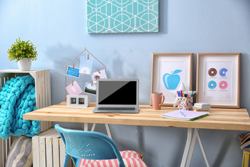 Comfortable workplace with laptop on table in modern room
