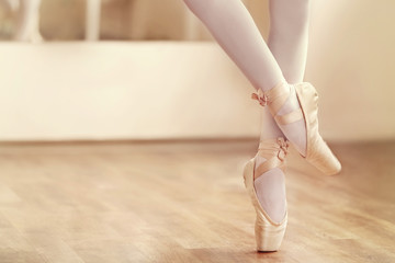 Fototapeta premium Legs of ballerina in ballet shoes, closeup