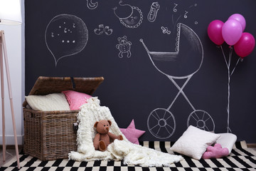 Chest with pillows and plaid in modern baby room