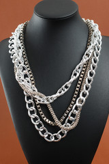 Woman's necklace on black leather mannequin