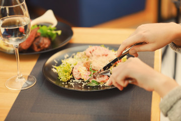 Client eating tasty Caesar salad in restaurant, close up