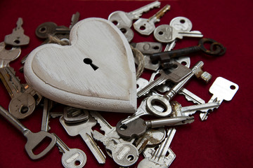 White wooden heart shape with a keyhole on a lot of keys, love concept for the one and only