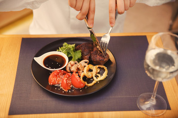 Client eating tasty dish in restaurant, close up