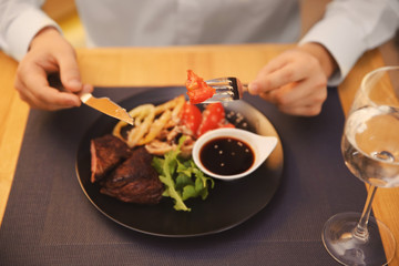 Client eating tasty dish in restaurant, close up