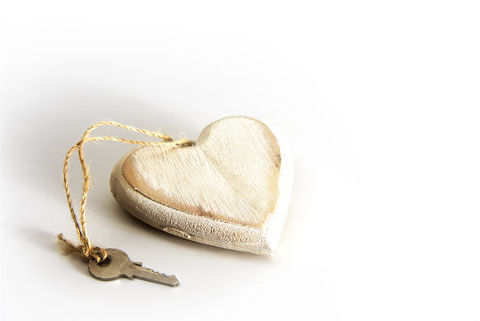 Heart from wood with a key on a gray white background, love concept for valentine's or mother's day
