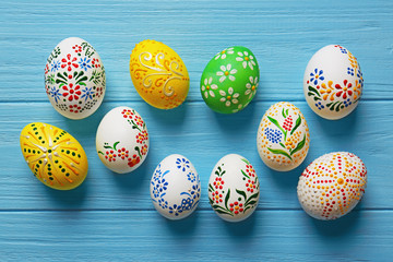 Beautiful Easter eggs with floral ornament on blue wooden background