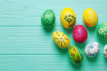 Beautiful Easter eggs with floral ornament on green wooden background