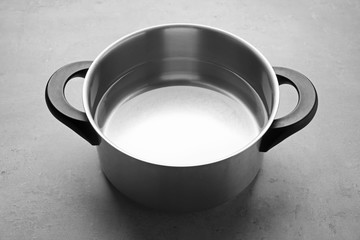 Stainless saucepan on grey table © Africa Studio
